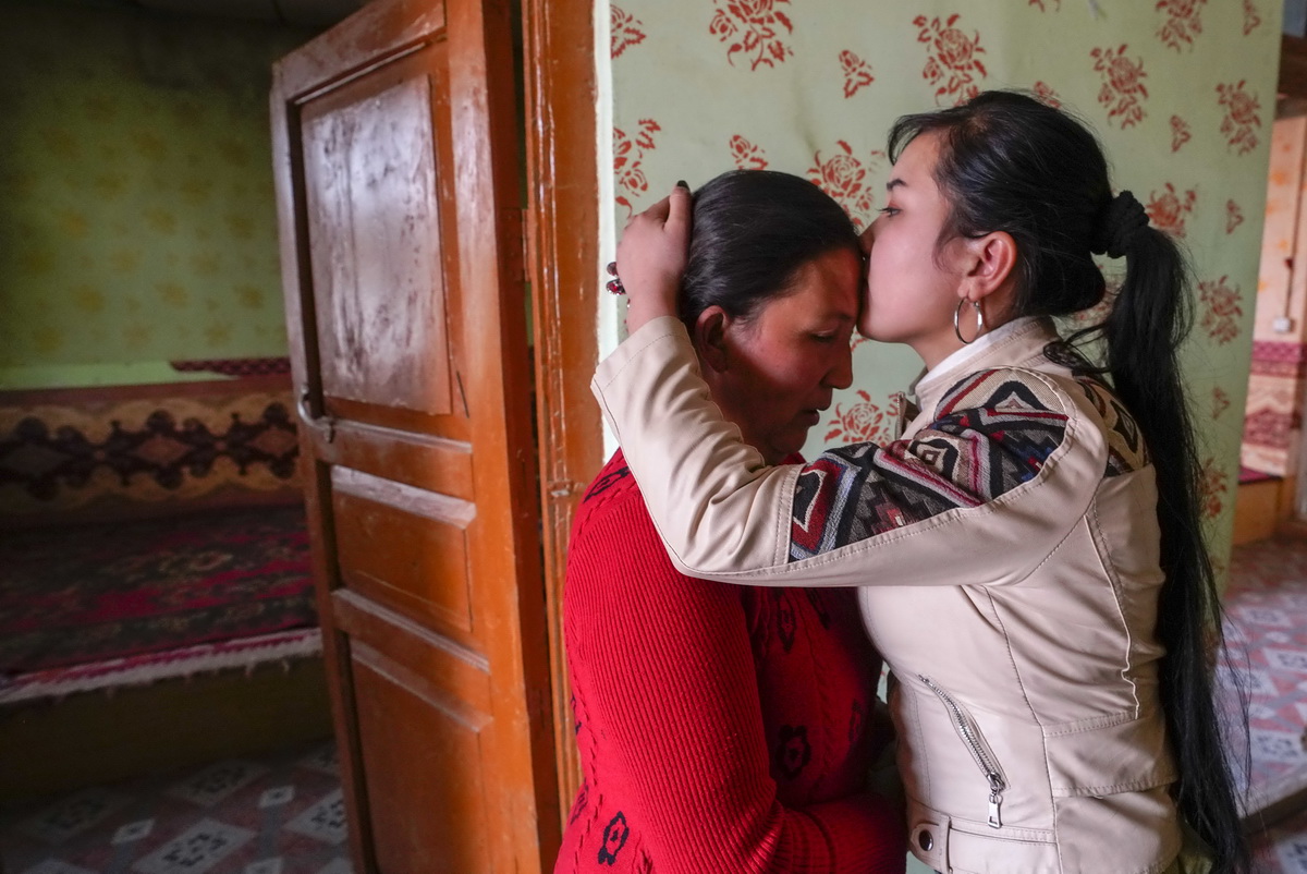 临行前，布再乃普·阿卜来海提（右）在和田墨玉县的家中亲吻自己母亲的额头（3月26日摄）。