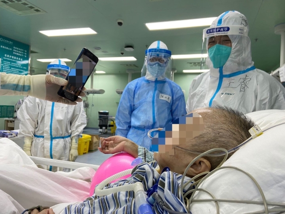4月22日晚，华中科技大学同济医学院附属协和医院西院ICU内，医护给其中一名病危患者看家人给她拍的加油视频。