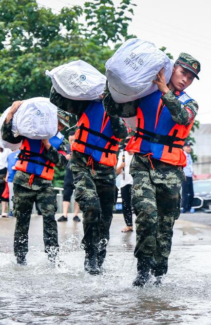 图片说明：2020年7月11日，武警安徽总队铜陵支队在搬运抗洪抢险物资。陈晨摄.png