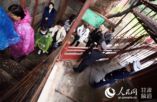 甘肃省森林消防总队指战员在位于甘肃省天水市的麦积山景区内疏导游客。(裴海博 摄)