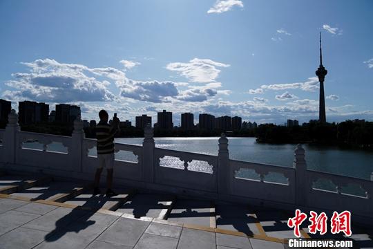 资料图：北京玉渊潭公园，一游客拍摄蓝天白云美景。<a target='_blank' href='http://www.chinanews.com/'><p  align=