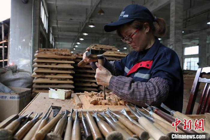 从事木雕技艺30多年的葛升芳正在雕刻一件木窗花刘浩摄