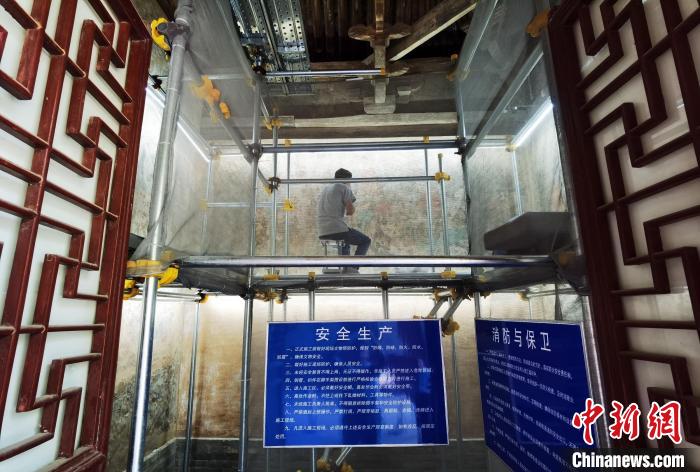 敦煌研究院文物保护技术服务中心的工作人员正在修复壁画。　胡健摄