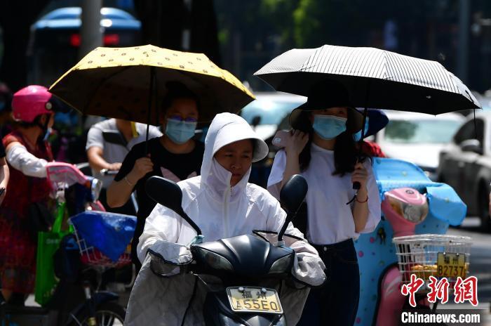 资料图：6月17日，福建福州市民烈日下“全副捂装”出行。　张斌 摄