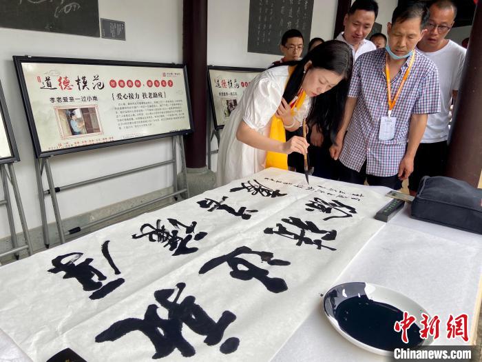 书法爱好者写下“敦厚退让，积善余庆”项菁摄