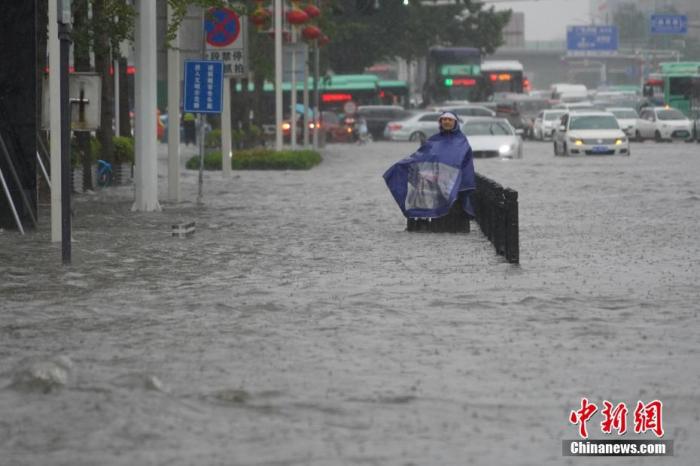 7月20日，河南郑州，市民冒着暴雨出行。近日，郑州连遭暴雨袭击，持续强降雨导致部分街道积水严重。 <a target='_blank' href='http://www.chinanews.com/'><p  align=