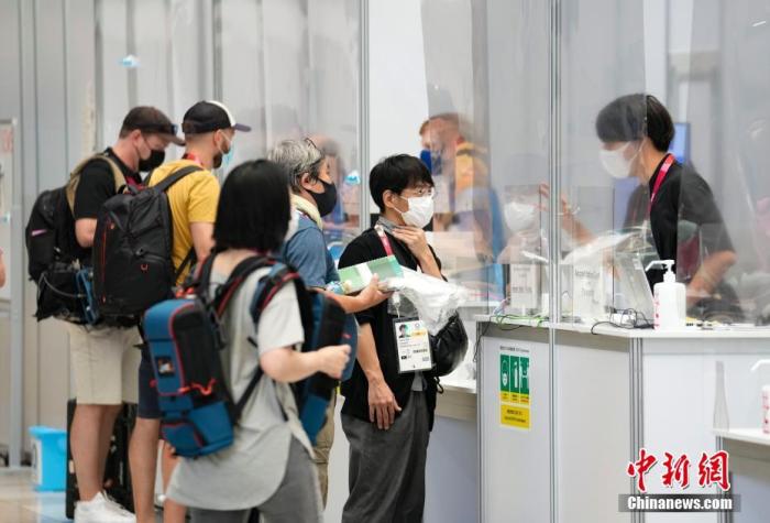 当地时间7月20日，东京奥运会主新闻中心，记者在服务台向志愿者咨询，服务台上一道塑料帘将两边隔开。 <a target='_blank' href='http://www.chinanews.com/'><p  align=